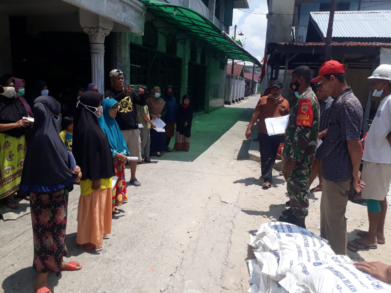 Menyongsong Hari TNI ke-76, Babinsa Kelurahan Sumahilang Bagikan Sembako ke Warga Gang Syuhada