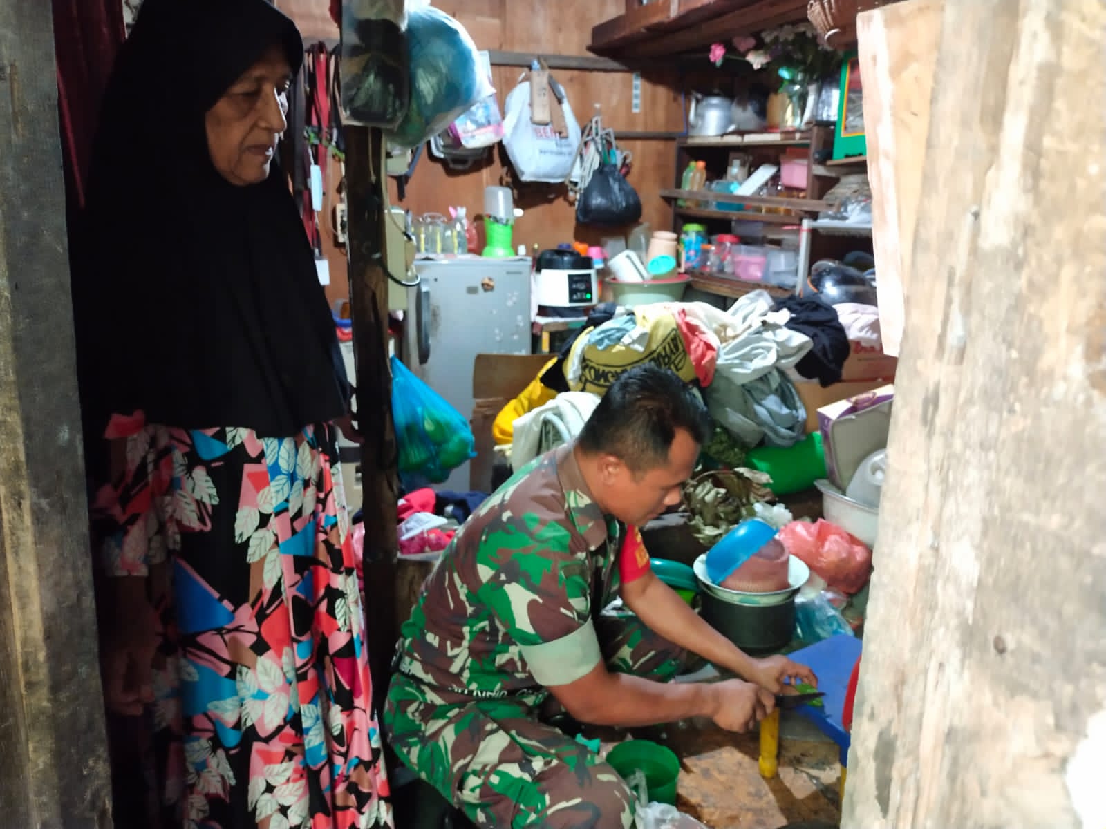 Babinsa Masuk Dapur, Serda Sumarsono Serahkan Bantuan Sembako dan Bantu Memasak 