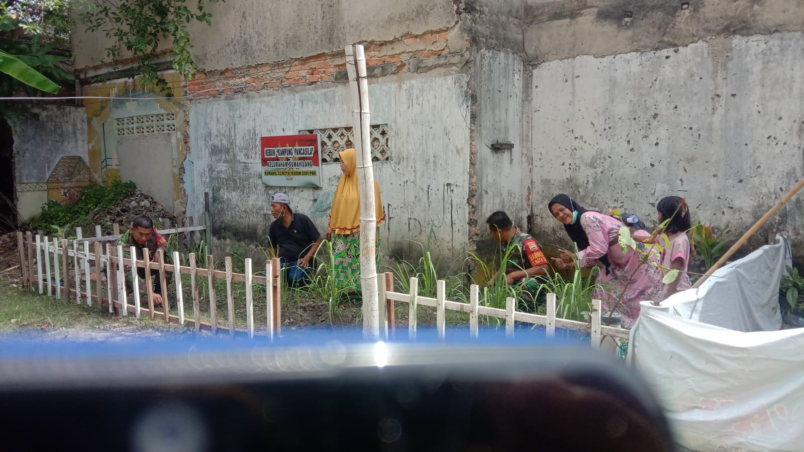 Babinsa Bersama Kader PKK Goro Bersihkan Gulma di Tanaman Obat Keluarga Kampung Pancasila 