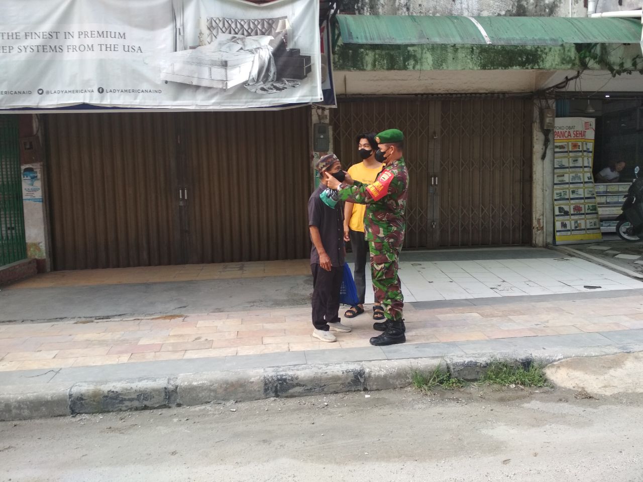 Babinsa Sukaramai Bagikan 50 Masker di Jalan HOS Cokroaminoto